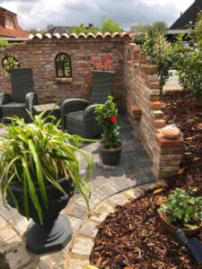 Ruinemauer mit Eisenfenster im Garten Gartenmauer an einer Terrasse