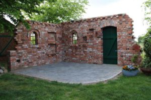 Ruinenmauer mit Holztür Ruinenmauer im Garten mit grüner Holztür